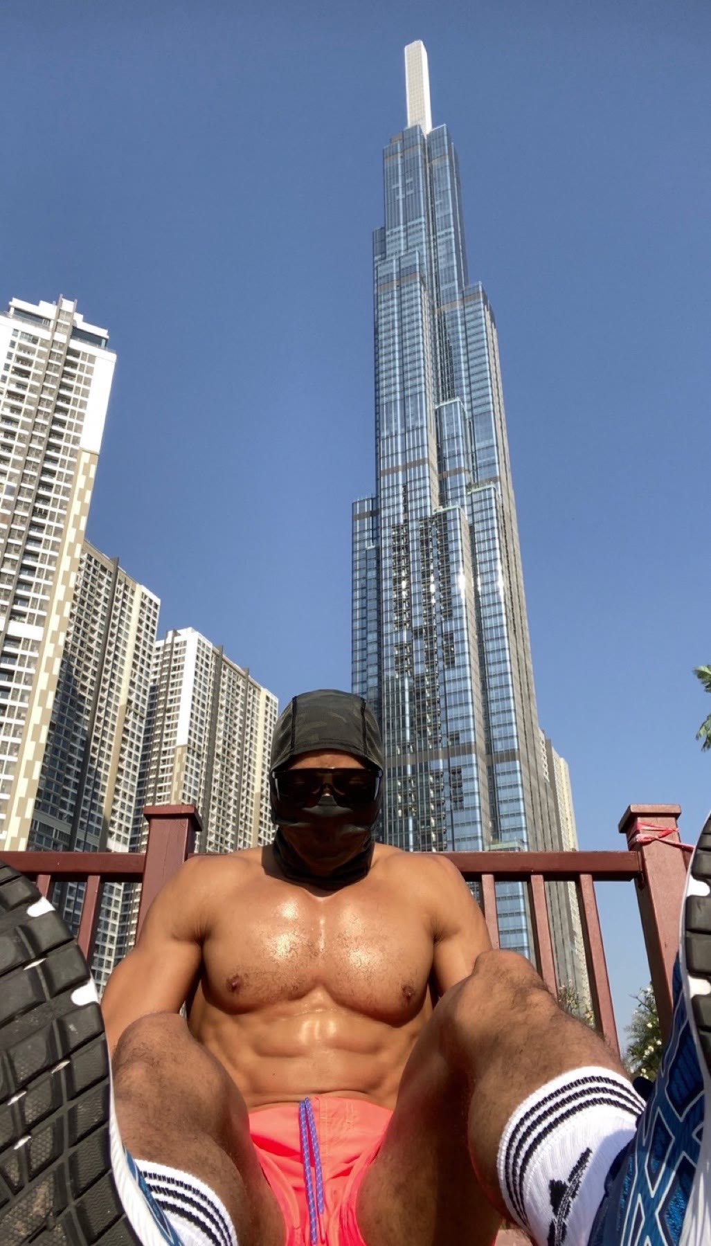 OYOTTA seated in training attire beneath a city tower